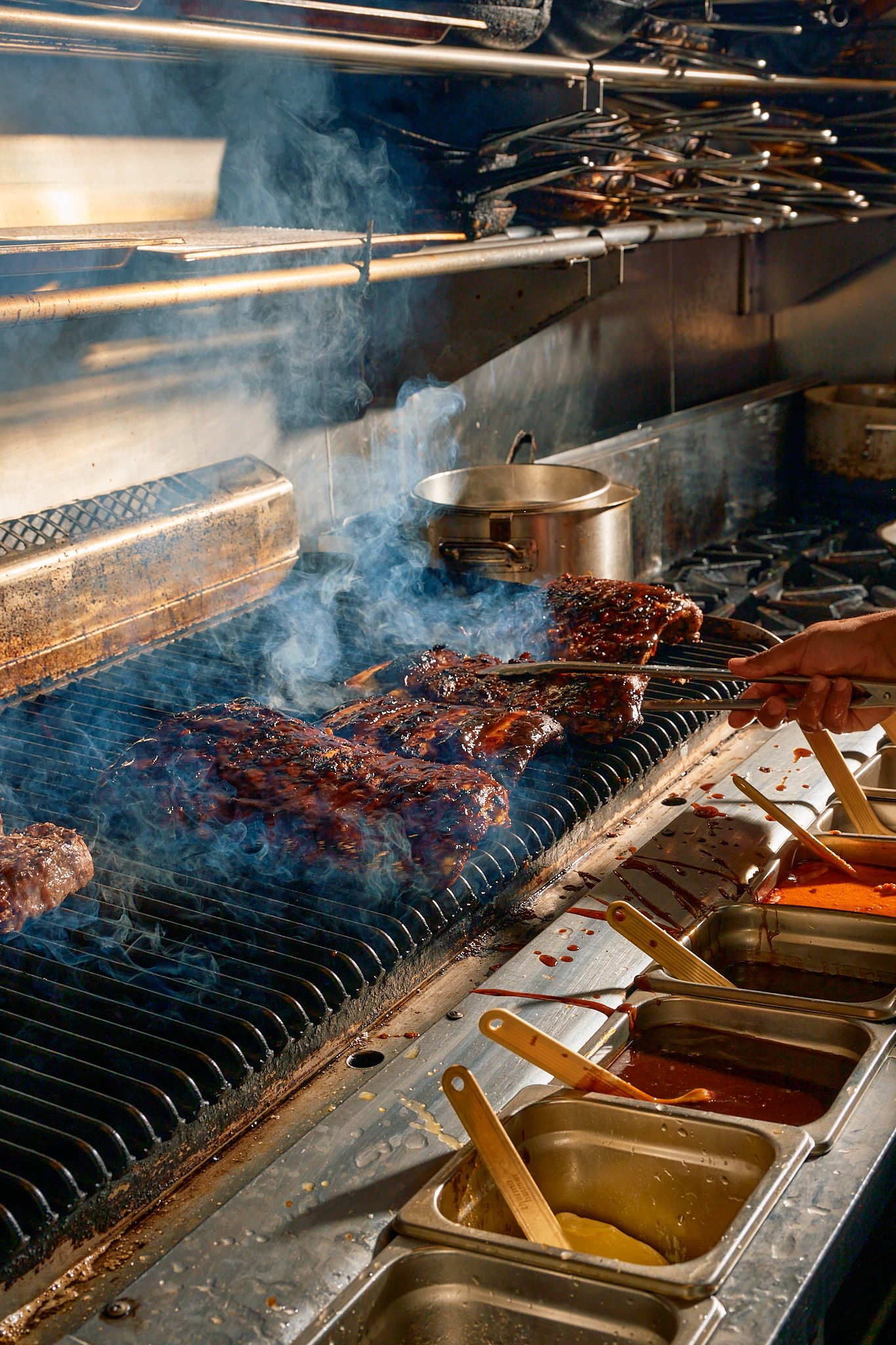 Ribs cooking over flame in the Times kitchen