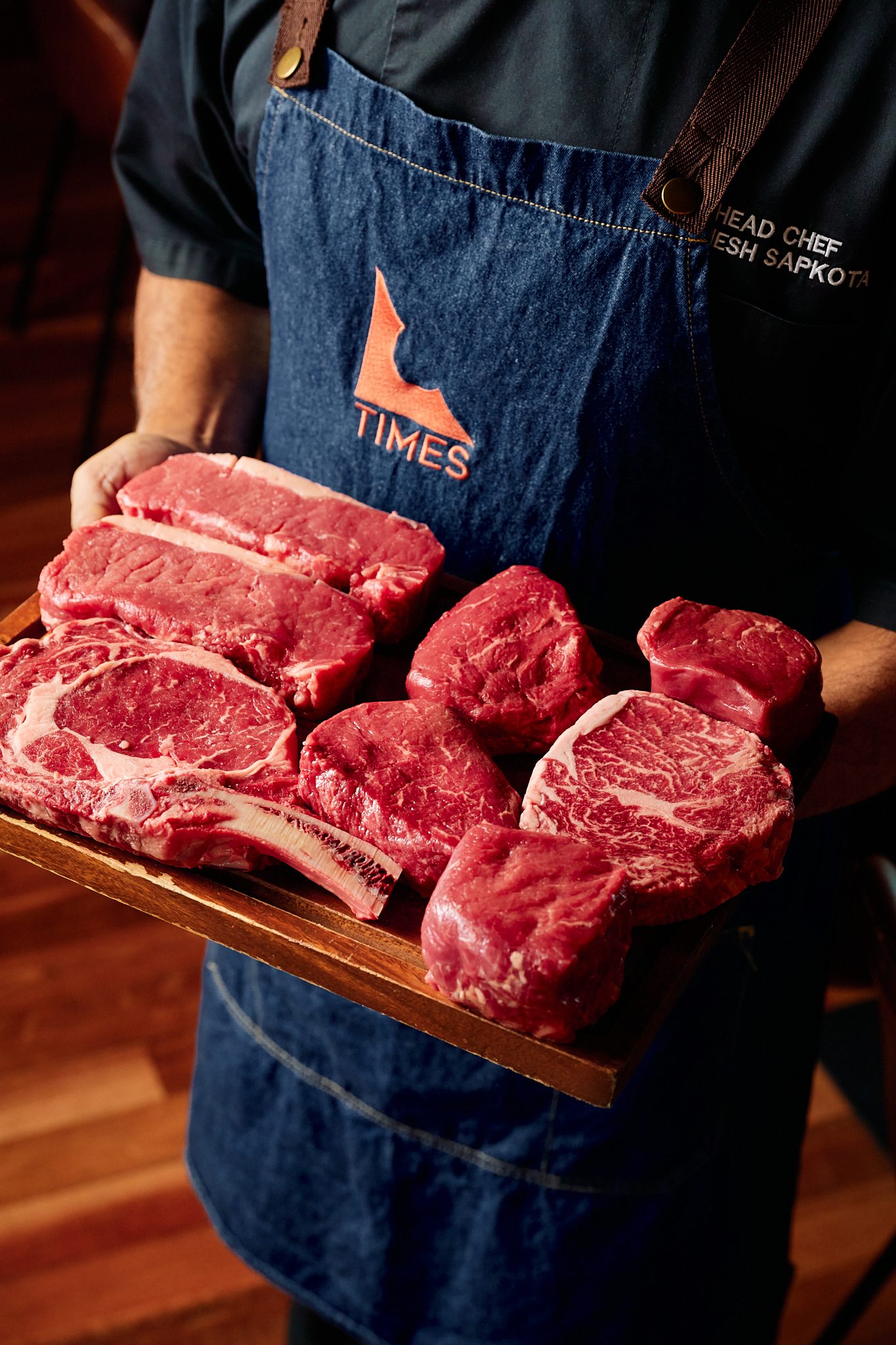 Premium steaks presented in a Times apron